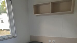 Ein Zimmer mit zwei Etagenbetten, einem Fenster und einem Regal über den Betten.