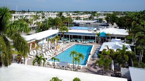 A resort with a central swimming pool surrounded by lounge chairs and palm trees. - Boot Key Harbor Retreat with Pool & Breakfast (Marathon)
