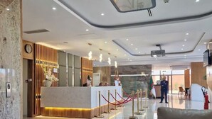 Eine Hotelhalle mit einer Rezeption, einer Uhr und einer Absperrschnur.