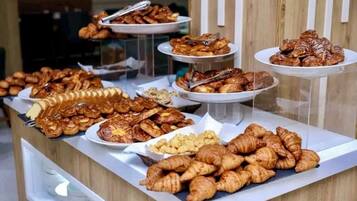 Un bufé con diversos pasteles y postres exhibidos en varios mostradores.