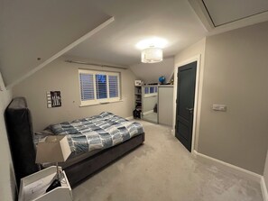 A bedroom with a bed, a desk, a chair, a wardrobe, and a window with blinds. - Family Friendly Home on Wild Atlantic Way (Furbogh)