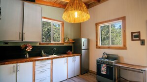 Una cocina con armarios de madera, estufa, fregadero y ventana.