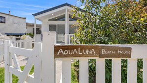 Puinen kyltti, jossa lukee ”Aqualuna Beach House”, ilmoittaa kiinteistön nimen.