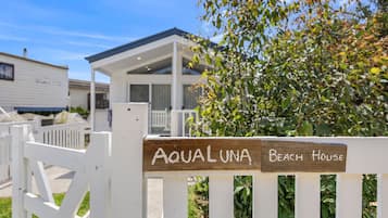 A wooden sign with 'Aqualuna Beach House' written on it, indicating the name of the property.