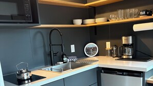 A compact kitchen with a microwave, coffee maker, and dishwasher.