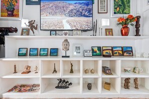 A well-organized living room with a television, various decorative items, and a bookshelf. - Luxury 4 BR House Inside The Walled City With Maid And Staff (cartagena)