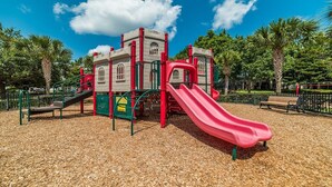 A playground with a red slide, climbing structures, and a castle-like play area. - Alm2809-101 (Kissimmee)