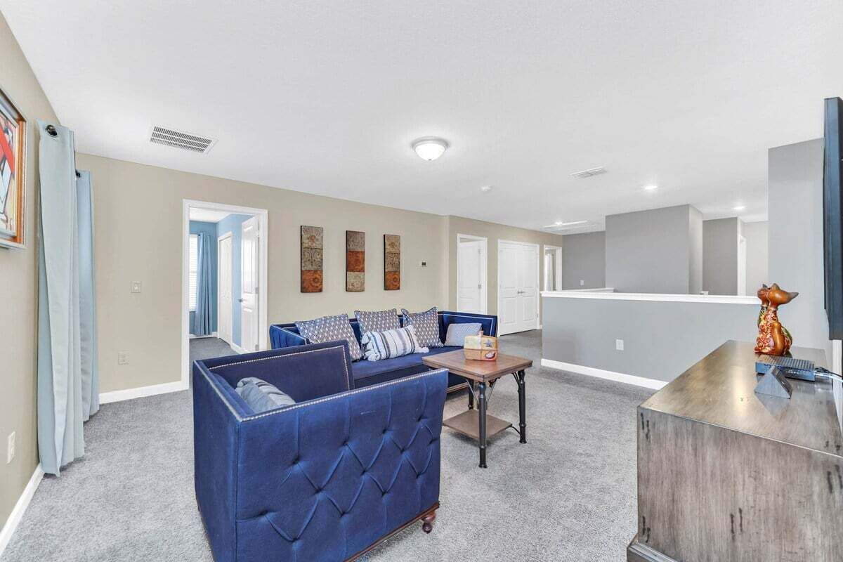 A living room with a blue sofa, a coffee table, and a TV stand.