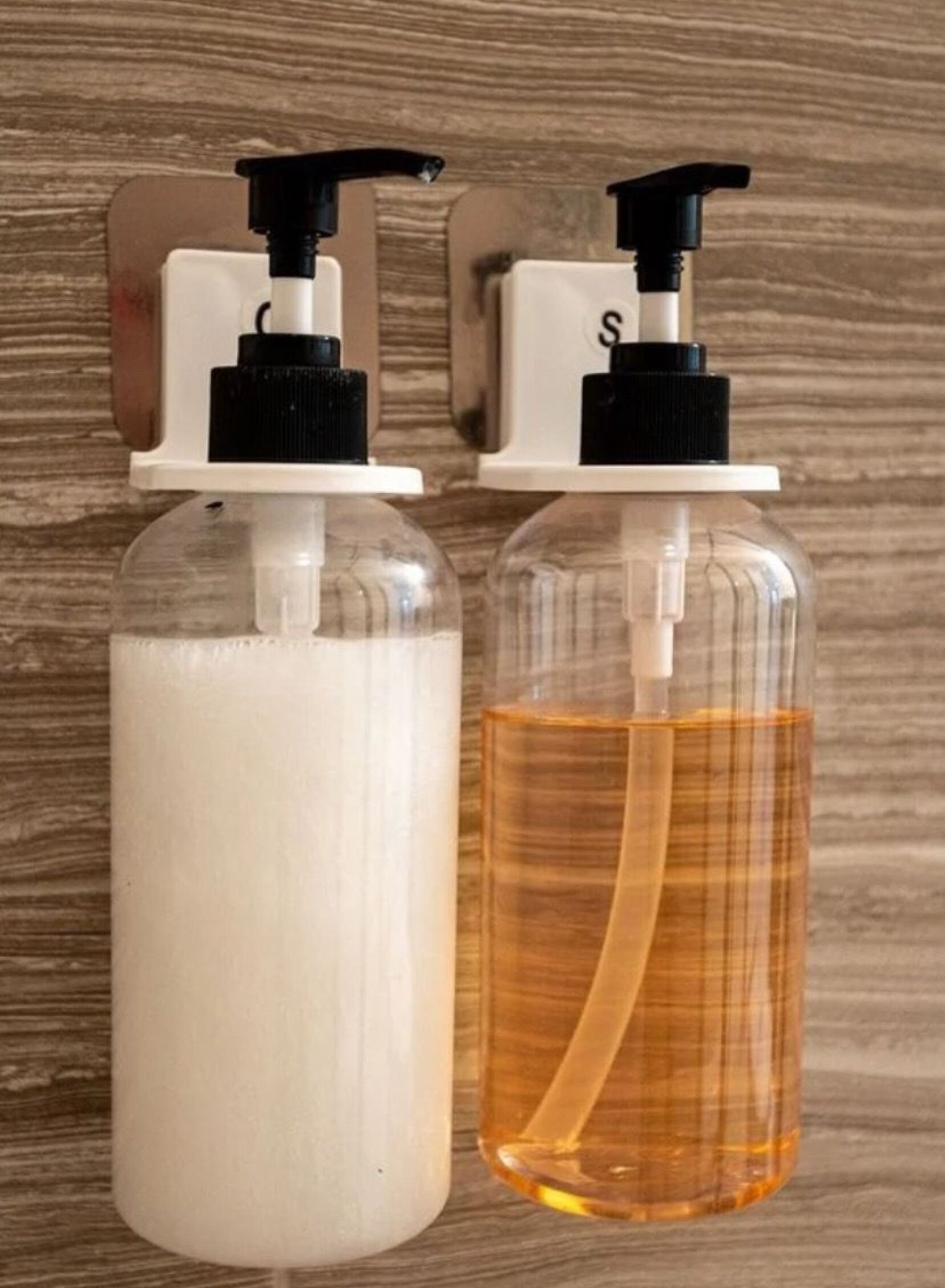Two hand soap dispensers mounted on a wall.