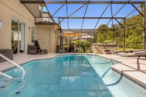 Una piscina all'aperto con lettini e ombrelloni, circondata da un portico coperto.
