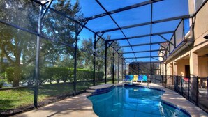 An indoor swimming pool with a glass enclosure, surrounded by a fence, and a covered patio area. - 4011-ol-music Genres Themed With Bowling Alley (Davenport)