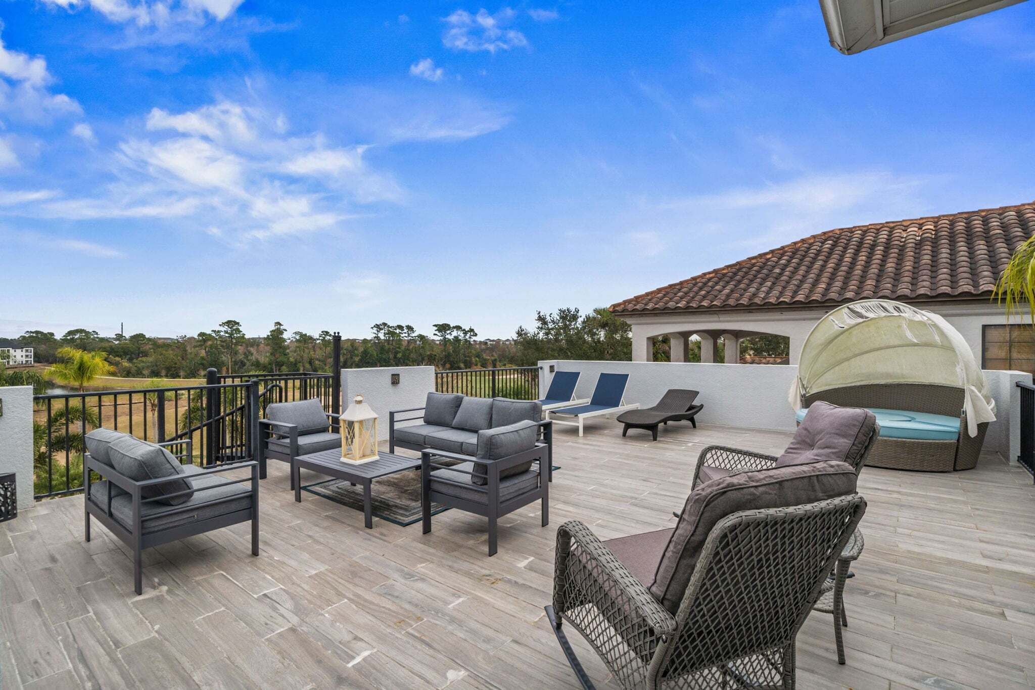 Eine überdachte Terrasse im Freien mit Möbeln, einer Pergola und Blick auf die Landschaft.