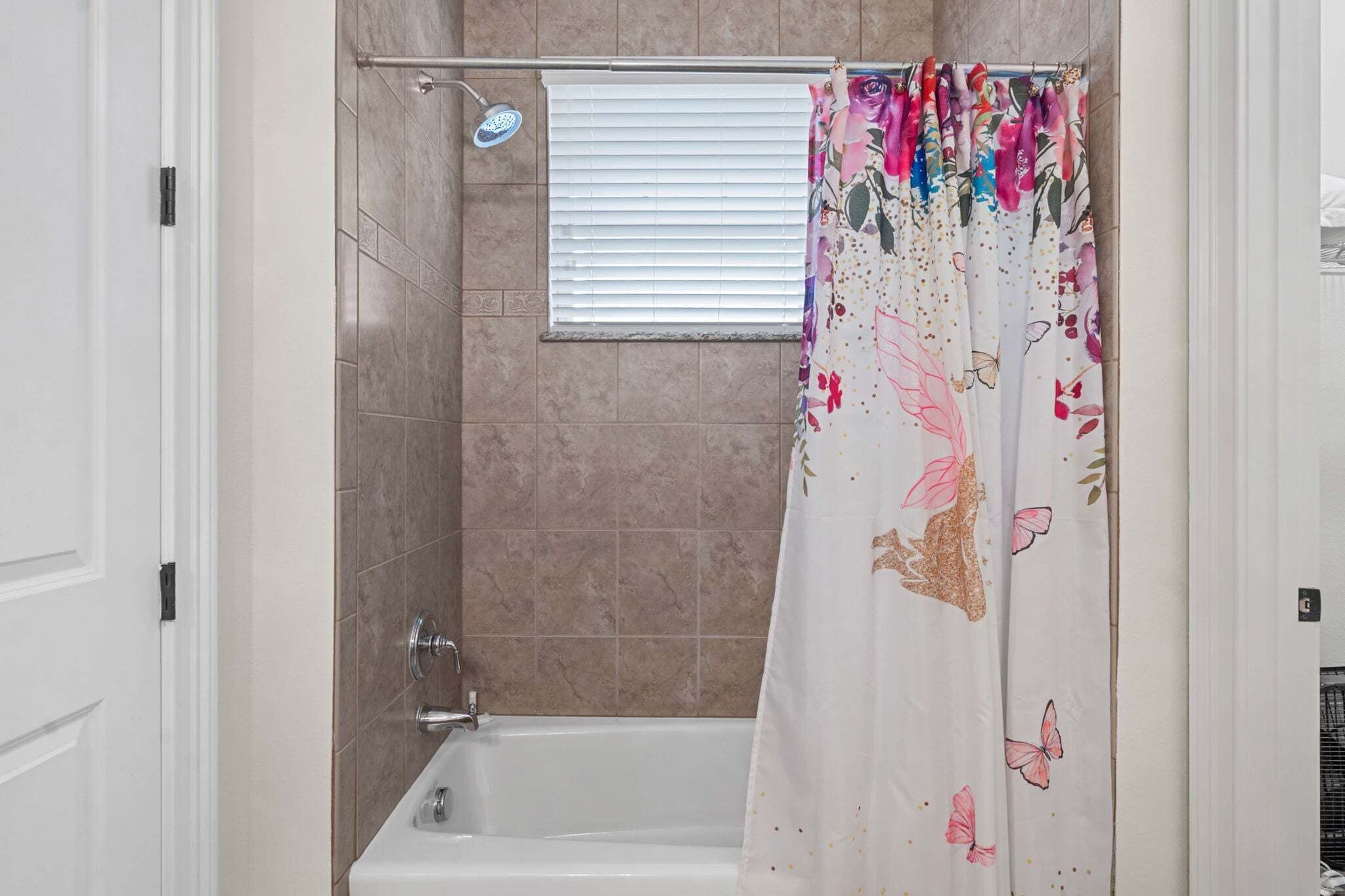 Un bagno con doccia, vasca e una finestra con persiane.