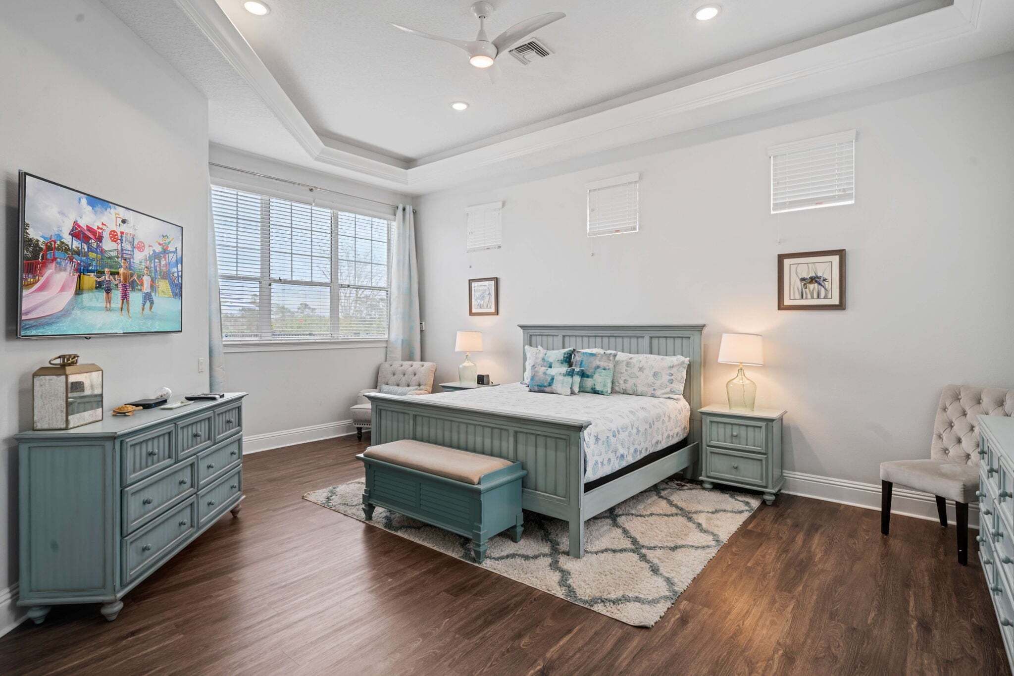 A bedroom with a bed, dresser, nightstands, and a window.