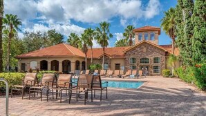 A resort with a swimming pool, lounge chairs, and palm trees. - Amazing Home in Davenport 4br 3.5 Bath (Davenport)