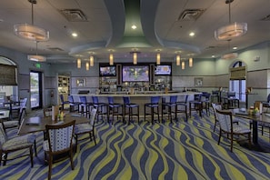 A hotel bar area with multiple seating options, a bar counter, and overhead lighting. - 1674 Moon Valley DR, Davenport, 6bed (Davenport)