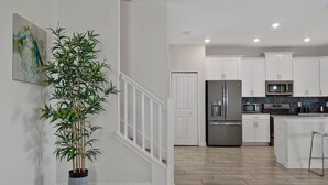 A modern kitchen with white cabinets, stainless steel appliances, and a herringbone wood floor. - 1674 Moon Valley DR, Davenport, 6bed (Davenport)
