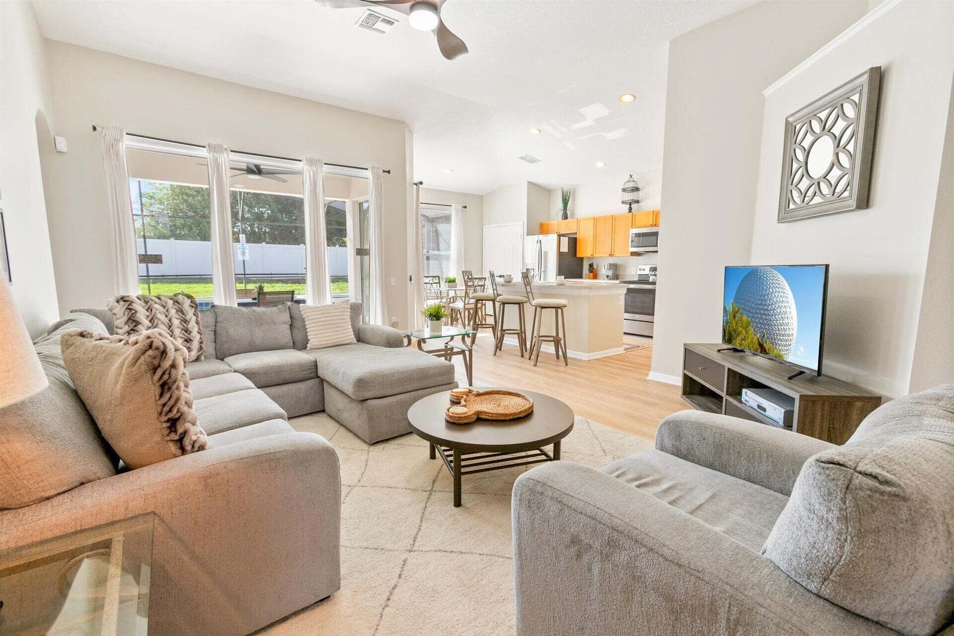 A modern living room with a sectional sofa, a round coffee table, and a TV.