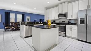A modern kitchen with white cabinets, stainless steel appliances, and a central island. - 360-7-pc-large and Luxury Villa (Kissimmee)