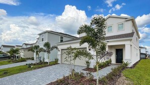 A modern two-story residential building with a garage, surrounded by well-maintained landscaping and a paved driveway. - Windsor Island Resort 5 Bedroom East Facing Pool - P820923 (Davenport)