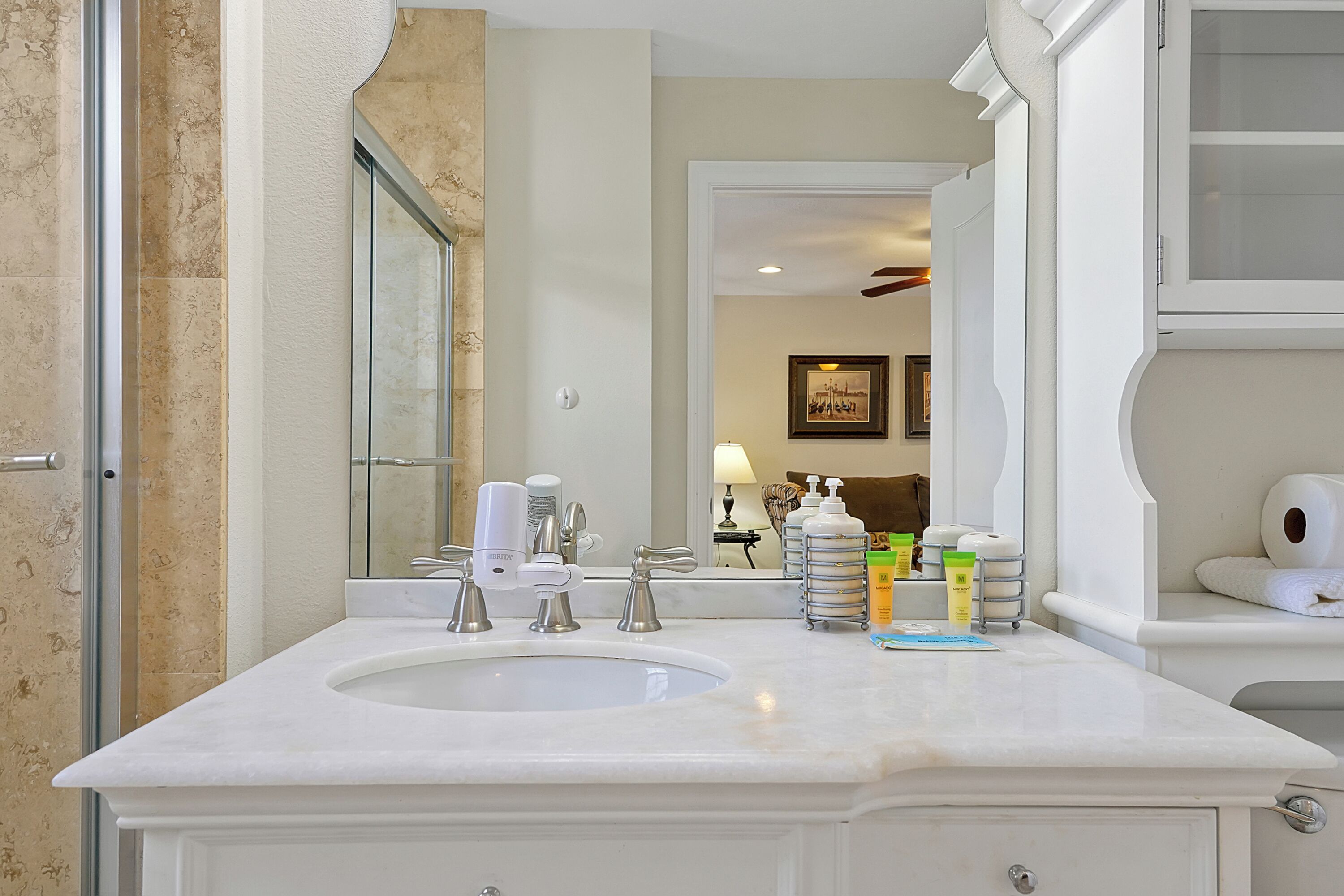 A bathroom with two sinks, a large mirror, and toiletries on the counter.
