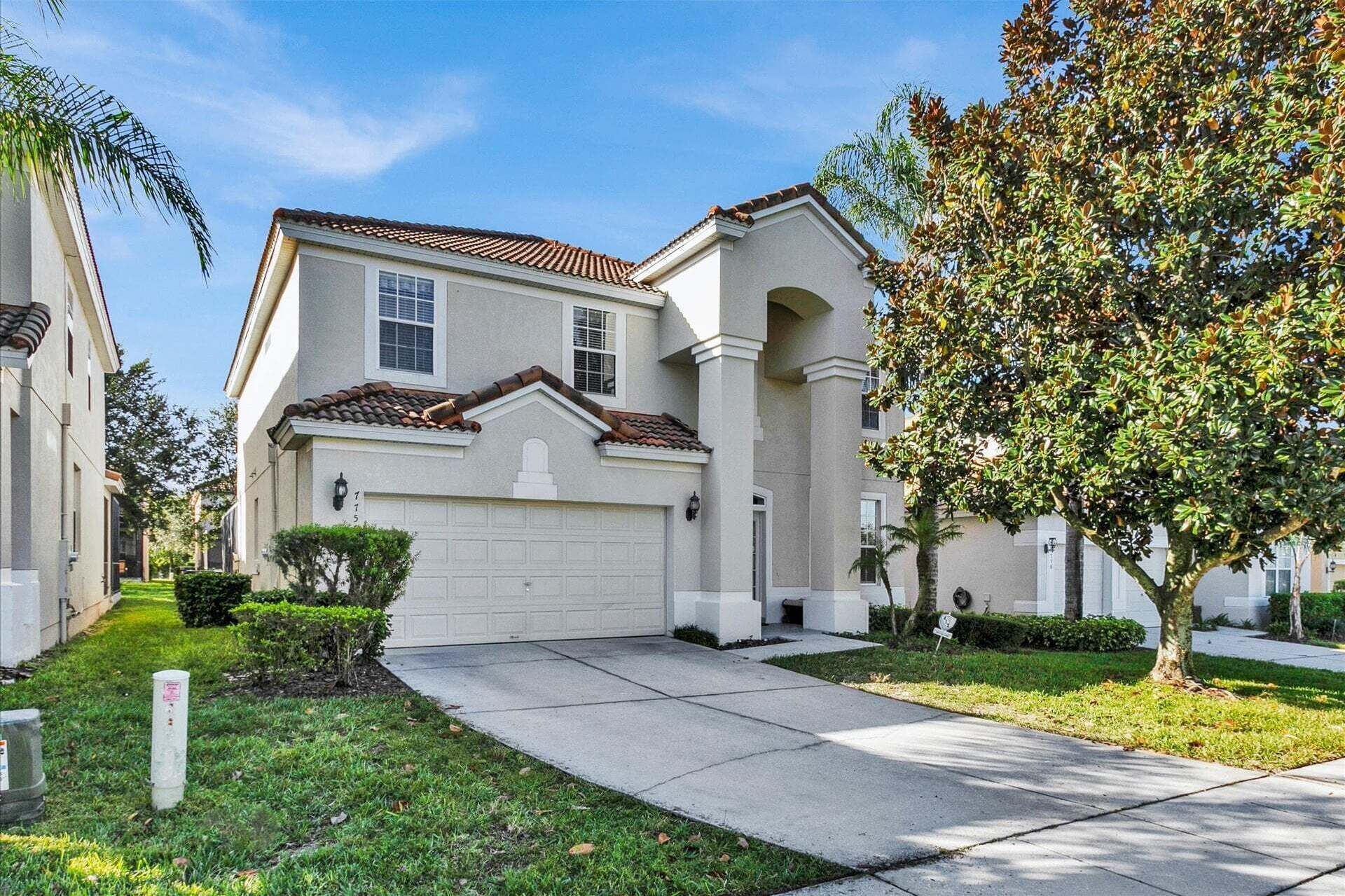 A residential house with a garage, a driveway, and a well-maintained lawn.