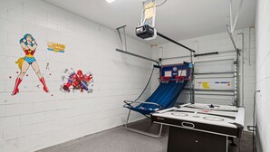 A room with a white brick wall, a projector mounted on the ceiling, a blue exercise ball, and a table with a white surface. - Kd912s Eagle Trace Marine (Kissimmee)