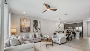 A modern living room with a sofa, armchair, coffee table, and artwork on the wall. - Kd912s Eagle Trace Marine (Kissimmee)