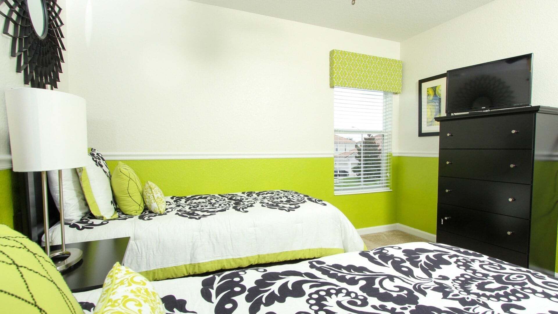 Un dormitorio con cama, cómoda, ventana con persianas y espejo adosado a la pared.