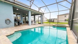 En swimmingpool med en täckt uteplats, en grill och en vattenslang.