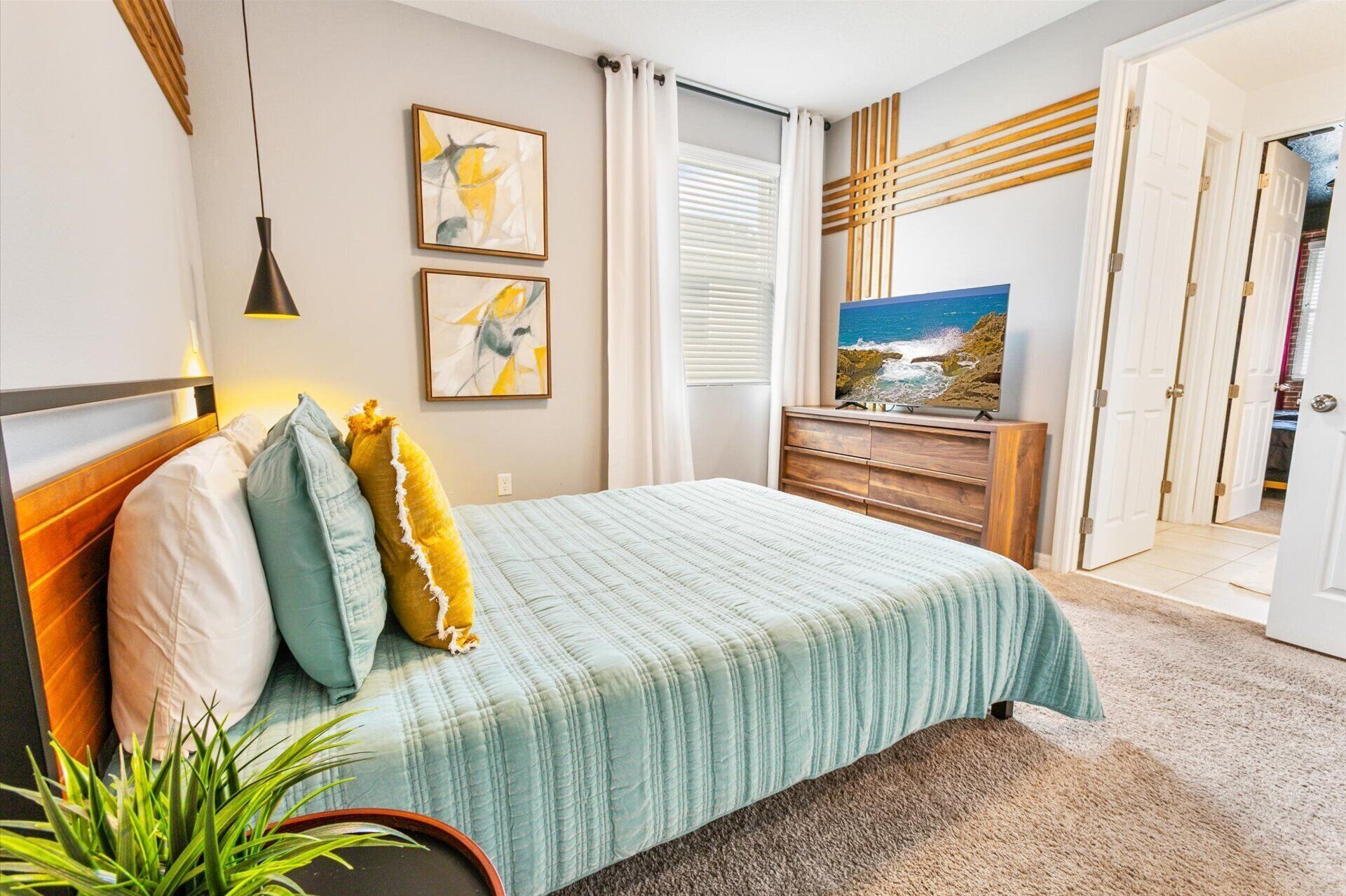 A bedroom with a bed, a TV, and a view of the sea.