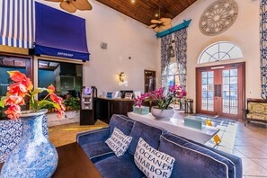A lobby with a reception desk, seating area, and a large window. - Special Offer Stunning Townhome With Private Pool Close to Disney 8960pp (Kissimmee)