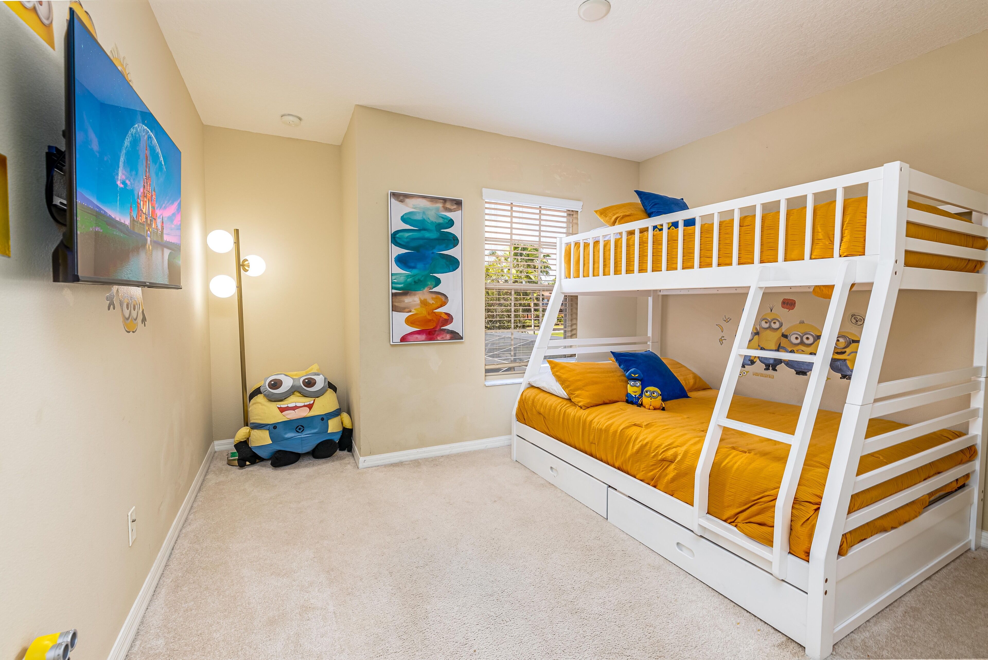 A child's bedroom with a bunk bed, a TV mounted on the wall, and a Minion-themed toy.