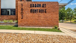 Un edificio de ladrillo con un cartel que dice "URBAN AT MONTROSE" y el número "1602".