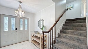 Eine Treppe mit hölzernen Geländern, einer Holzbank und einem Chandelier.