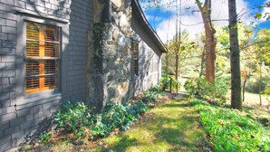 Ein Haus aus Stein mit einem Fenster und einer Steinmauer.