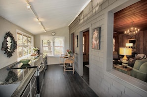 A kitchen with a dining area, a chandelier, and a clock on the wall. - The Hideaway of Horse Cove (Highlands)
