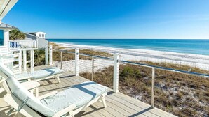 A beach view from a deck with lounge chairs and a railing. - Diamond Dunes (Panama City Beach)