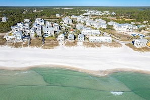 An aerial view of a coastal residential area with multiple multi-story houses, a sandy beach, and clear turquoise waters. - Diamond Dunes (Panama City Beach)