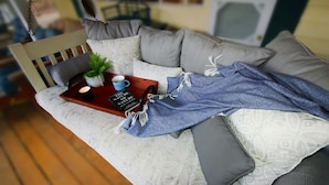 A cozy living room with a sofa, a tray with a book, a cup, and a plant. - Highlands Hideout (Highlands)