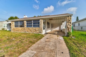 A single-story house with a stone facade, a covered porch, and a concrete driveway. - Shark Shack Large House Minutes to the Beach (Holly Hill)