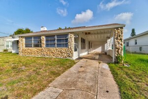 A single-story house with a stone facade, a covered porch, and a concrete driveway.