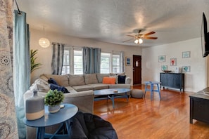 A living room with a sofa, coffee table, and a dining area with a table and chairs. - Shark Shack Large House Minutes to the Beach (Holly Hill)
