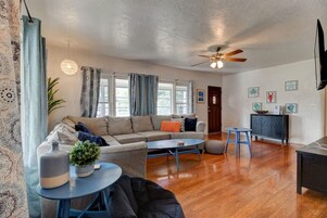 A living room with a sofa, coffee table, and a dining area with a table and chairs.
