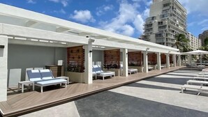 Un espace aménagé au bord de la piscine, avec des chaises longues et un coin salon abrité.