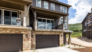 A two-story house with a stone facade, a large garage, and a balcony. - Modern Mountain Retreat Sleeps 10 Park City (Heber City)