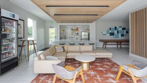 Ein modernes Interieur mit einem Ecksofa, einem runden Couchtisch und Barhocker.