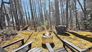 Bosque con un hogar y dos sillas Adirondack.