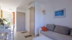 Una sala de estar moderna con un sofá, una mesa de comedor con sillas y un cuadro en la pared.