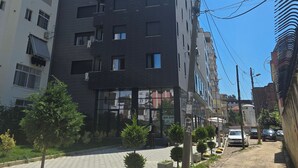 Ein modernes, mehrstöckiges Gebäude mit dunkler Fassade und zahlreichen Fenstern.